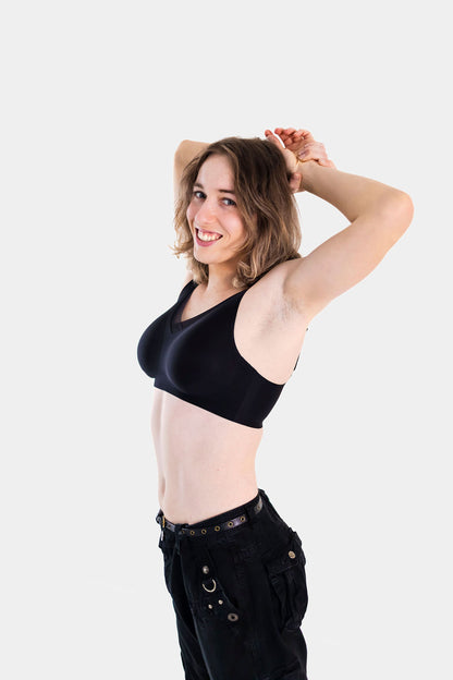 Woman wearing a black bra and black pants on a white background